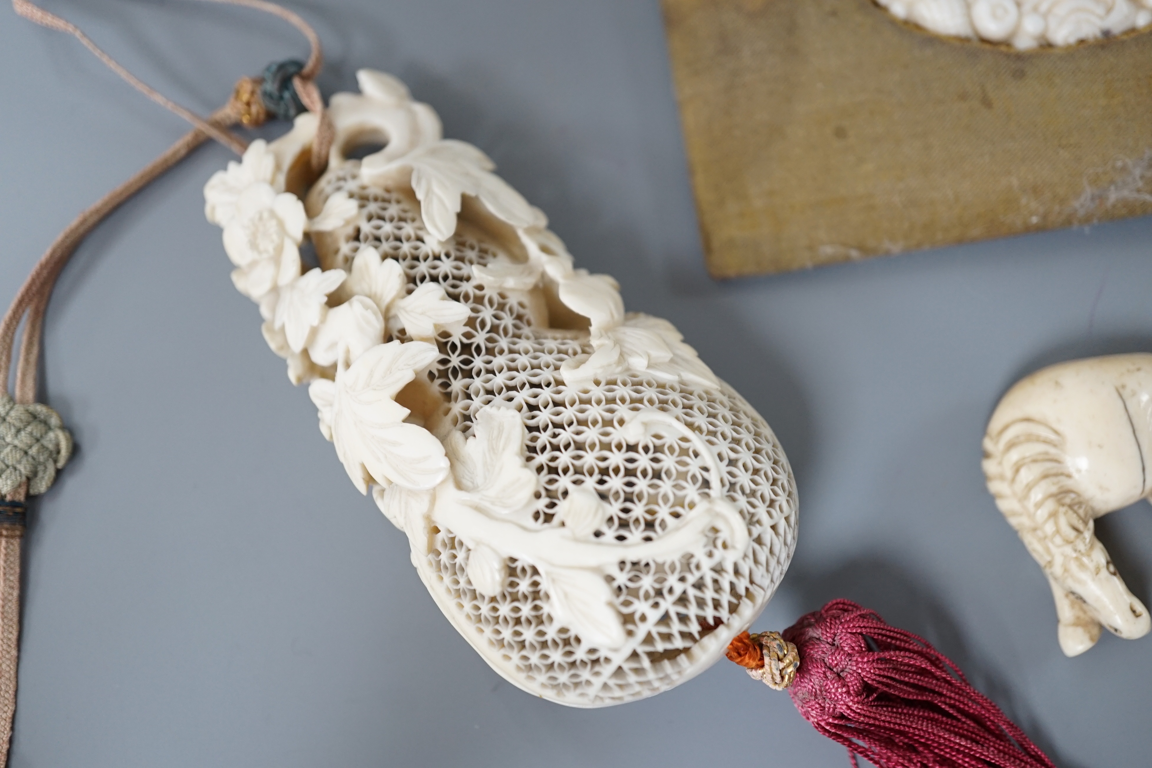 A 19th century Chinese pierced Ivory scent box together with a netsuke modelled as a horse and ivory pierced panel (3)